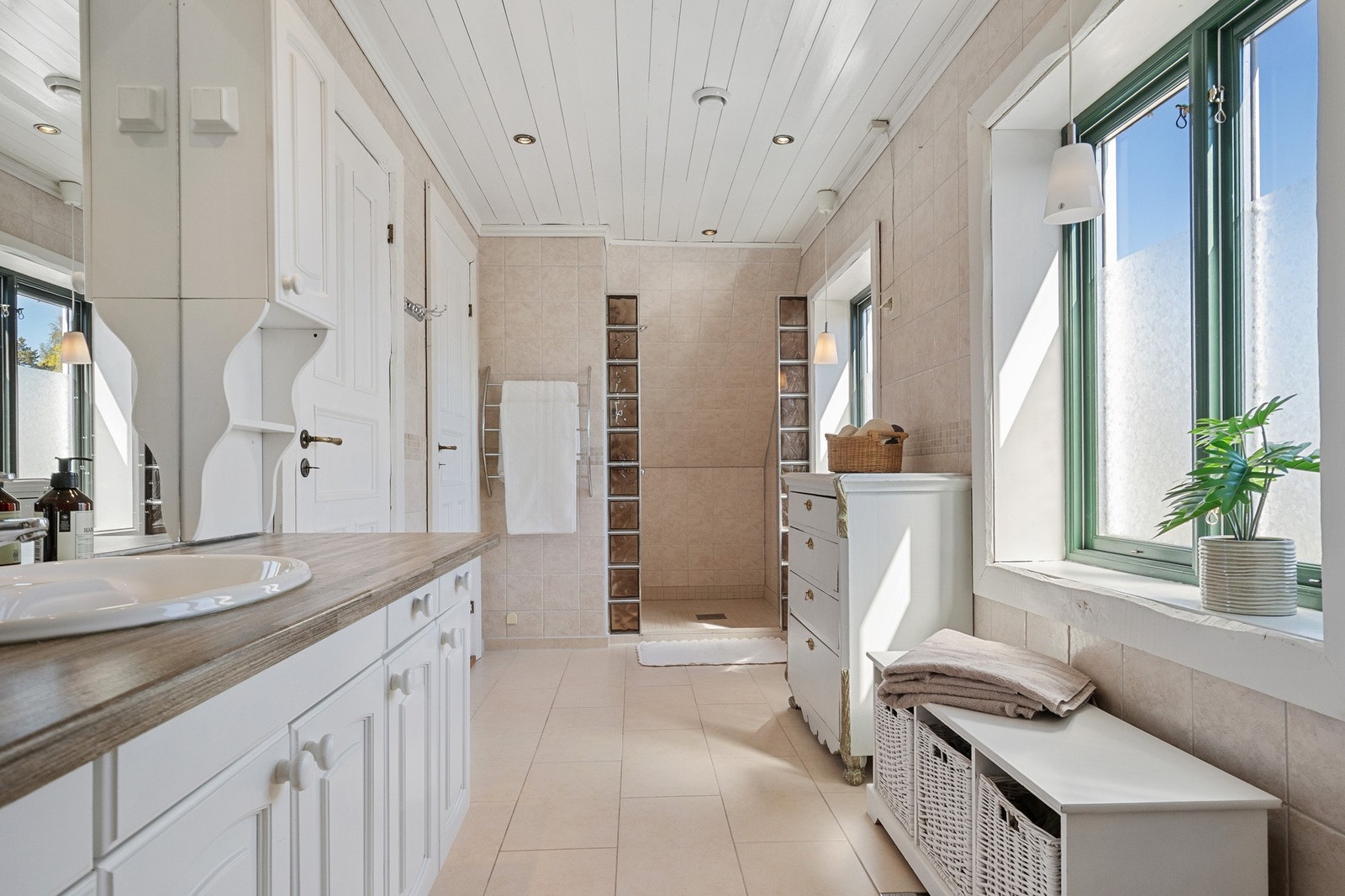 Badet i 2. etasje er innredet med servantinnredning, dusjnisje og wc. Rommet har flislagte vegger og gulv med elektrisk gulvvarme, noe som gir en lun og behagelig atmosfære. Galleribilde
