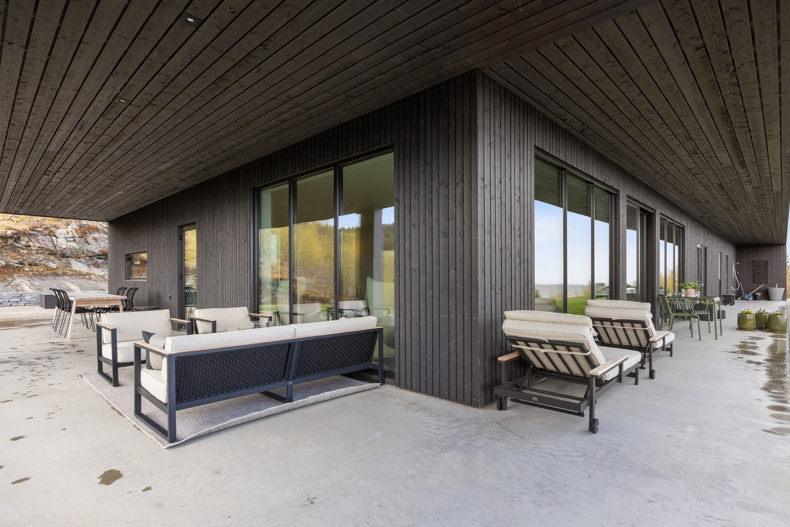 Støpt plate med terrasse under tak rundt halve boligen Galleribilde