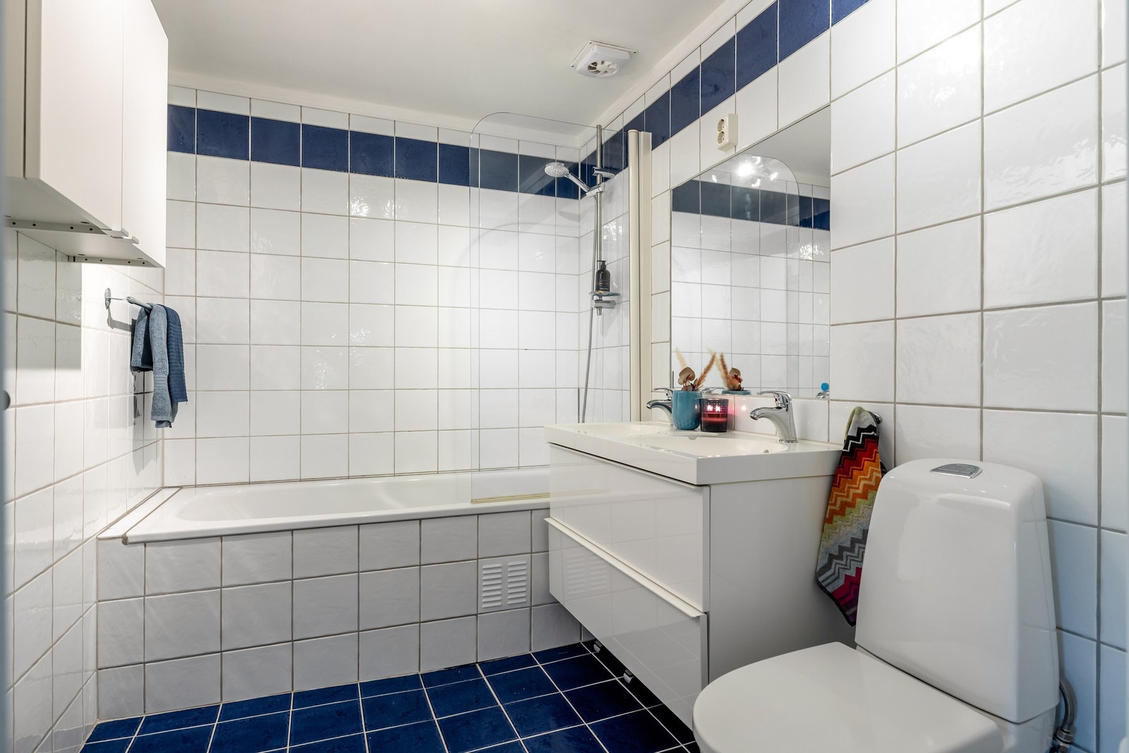 Badet i 2. etasje er flislagt og er innredet med innmurt badekar med dusjløsning, dobbel servant med oppbevaring i underskap og toalett. Galleribilde
