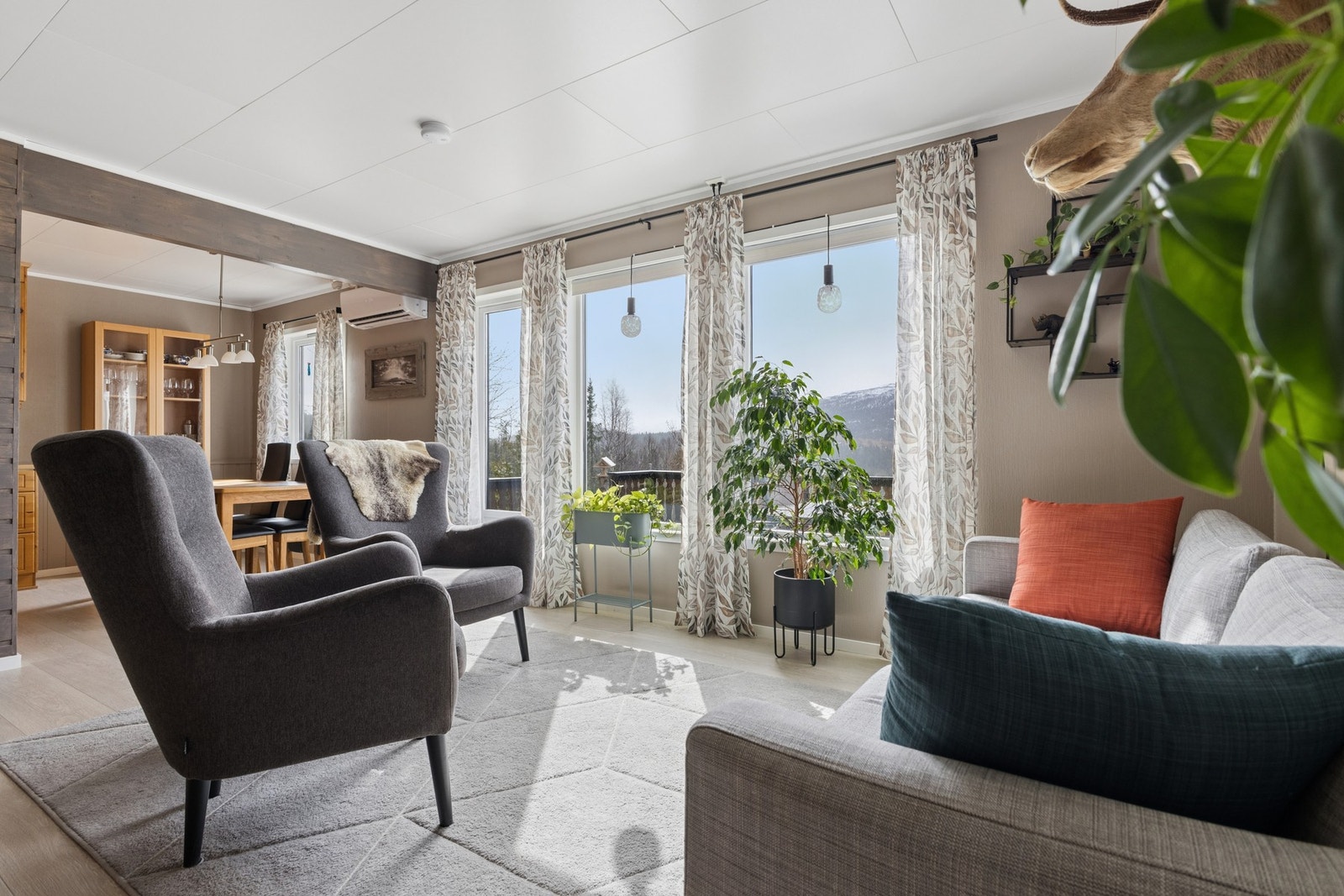Stuen i første etasje har plass til både sofagruppe og spisebord, med utgang til terrassen. Galleribilde