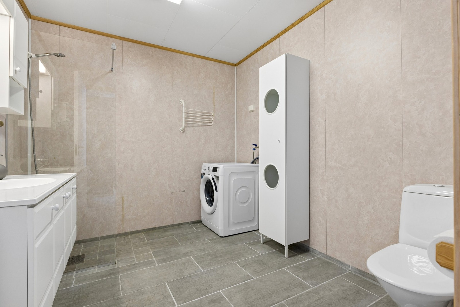 Badet er kombinert vaskerom med opplegg for vaskemaskin. Galleribilde