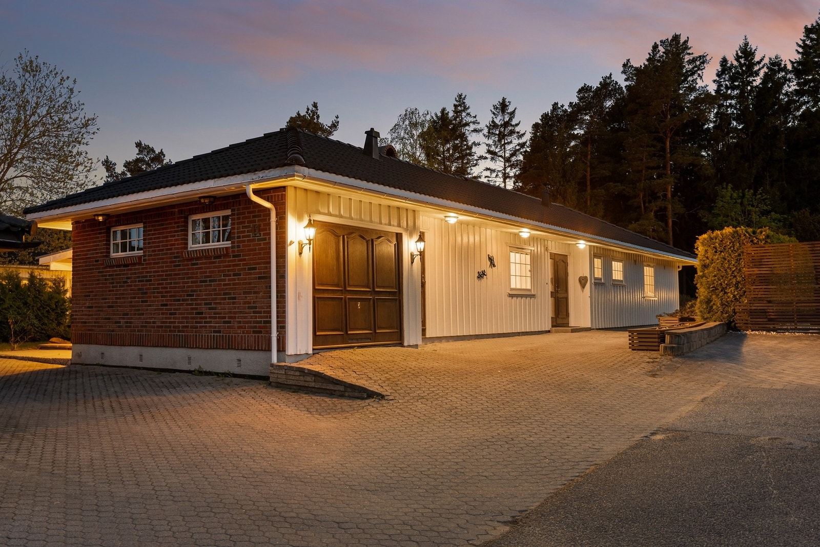 Ekstern garasje og sportsbod er integrert i bygningskroppen og gir praktiske oppbevaringsmuligheter Galleribilde