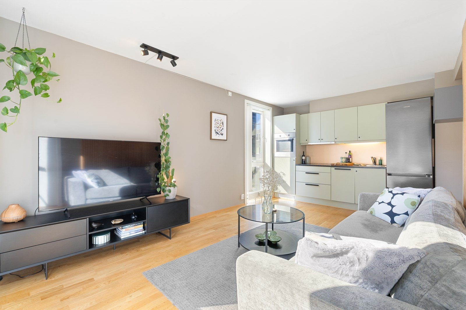 Leilighetens samlingspunkt inkluderer stue og kjøkken i en åpen løsning på 18 m², og har god plass til både sofa og spisebord. Galleribilde
