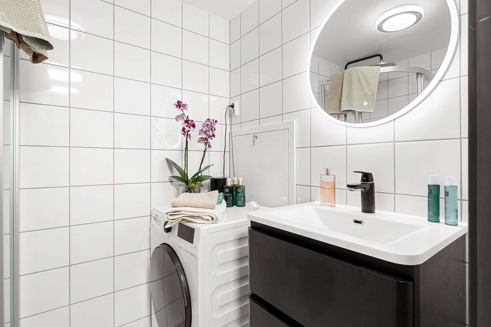Badet er fullt utstyrt med dusjdører/dusjhjørne, mekanisk avtrekk og gulvmontert toalett. Videre er det servant med underskap og praktisk opplegg for vaskemaskin. Galleribilde