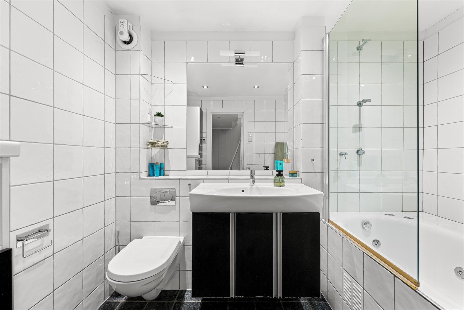 Badet er innredet med servantinnredning, speil med integrert belysning, badekar med spylefunksjoner og vegghengt toalett. Galleribilde