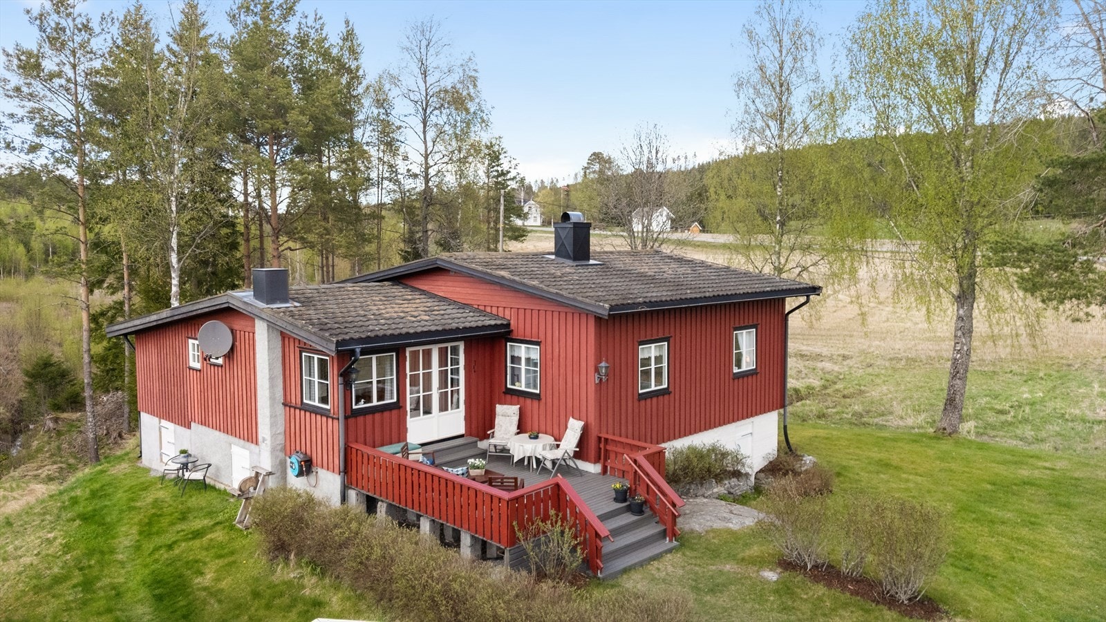 Hytta har en pent opparbeidet tomt med plenområder og prydvekster. I tillegg er det naturlig vegetasjon og høye trær. Galleribilde