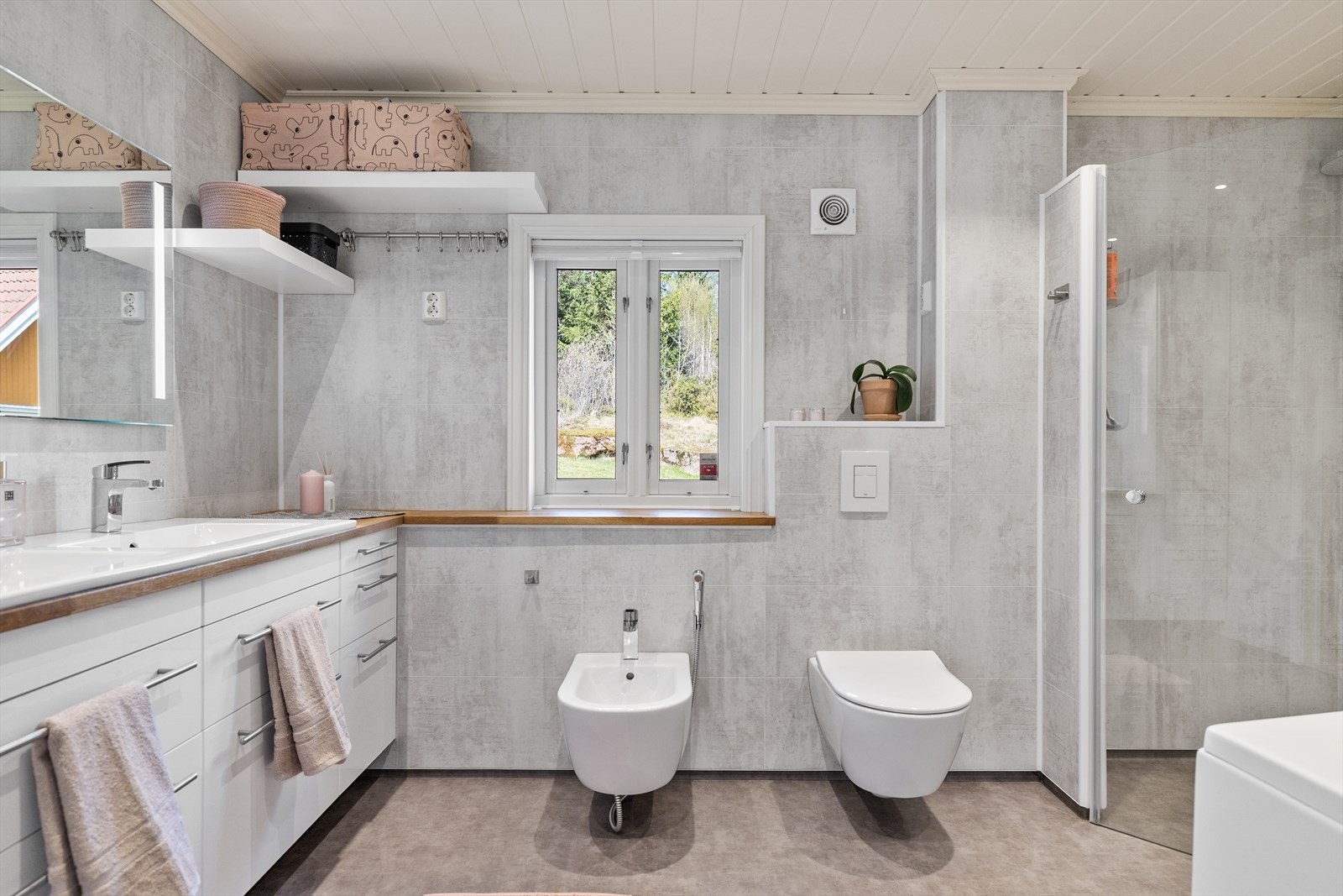 Innredet med servant, vegghengt toalett, bidet, badekar og dusj. Galleribilde