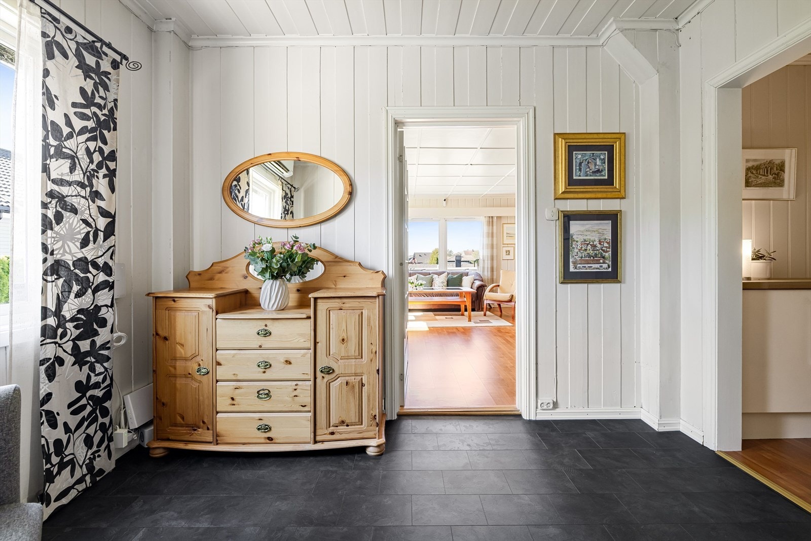 Videre er det en lys hall med adkomst til stue og til mellomgang som tar deg videre til kjøkkenet. Galleribilde