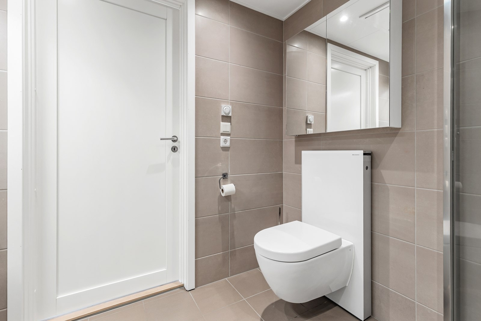 Badet er utstyrt med vegghengt toalett og har keramiske fliser på vegger og gulv. Galleribilde