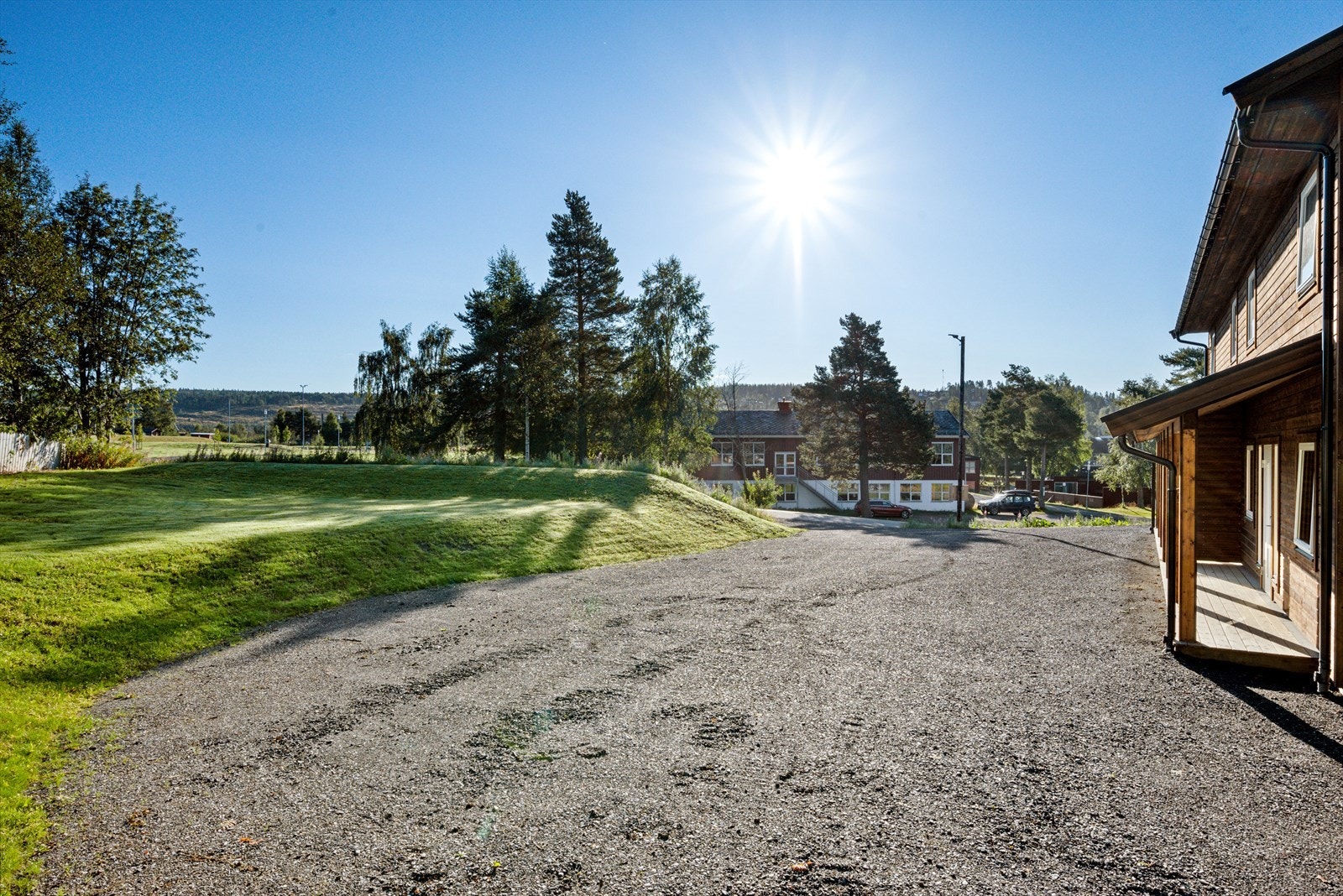 Ved inngangen er det et praktisk takoverbygg.Tomten har en stor gruslagt gårdsplass, med gode parkeringsmuligheter. Galleribilde