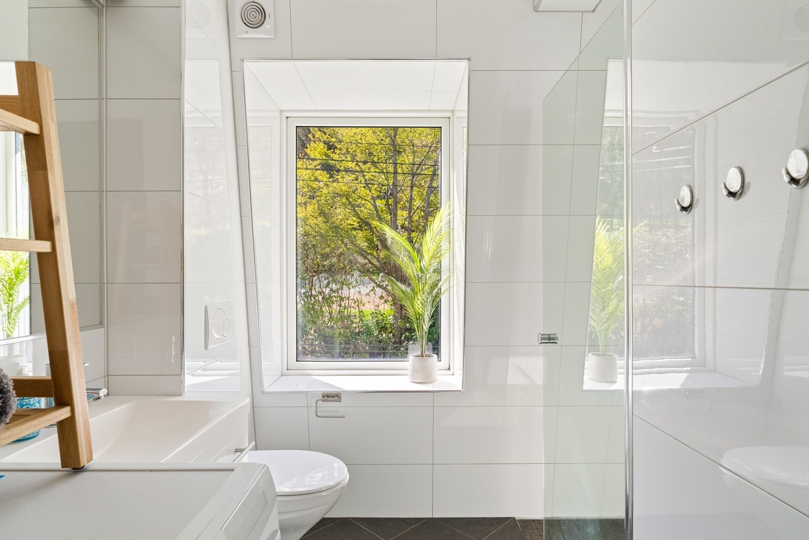 Badet er innredet med servant i innredning, vegghengt toalett, dusjløsning med dusjvegg samt opplegg for vaskemaskin. Et praktisk og stilrent bad med gode løsninger. Galleribilde