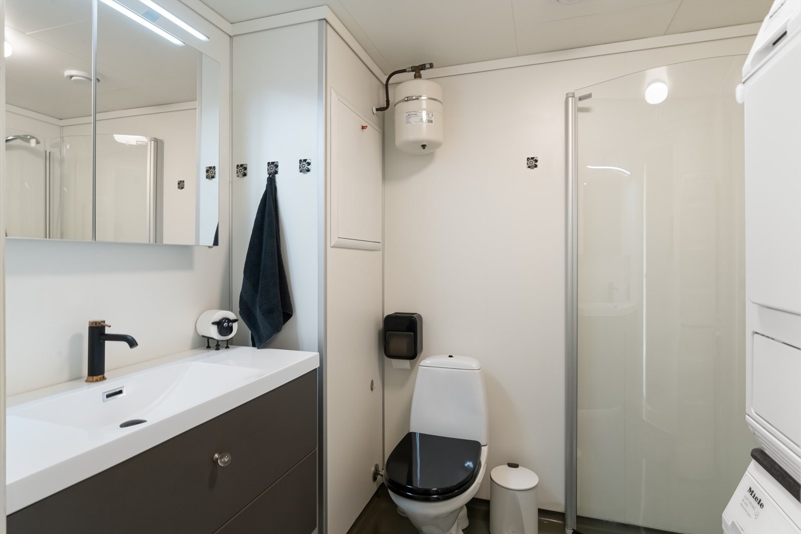 Lyst bad med baderomsplater på vegg og belegg på gulv. Galleribilde