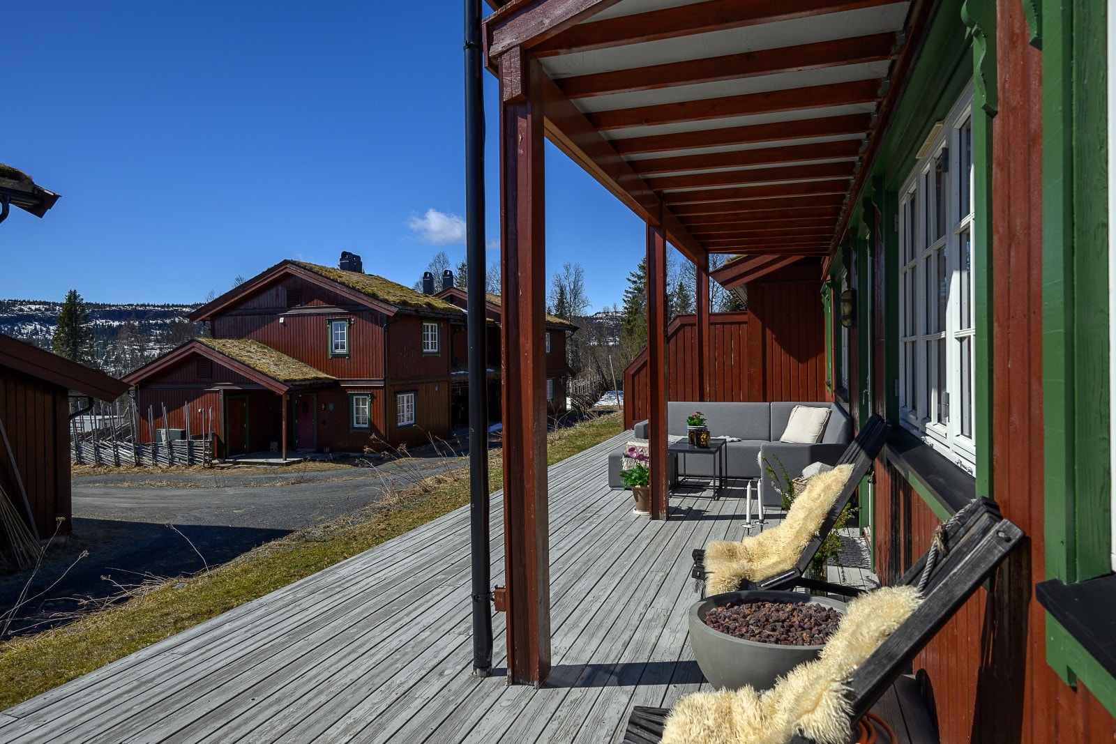 Den romslige terrassen i treverk er en naturlig forlengelse av stuen og et samlingspunkt på fine dager. Galleribilde