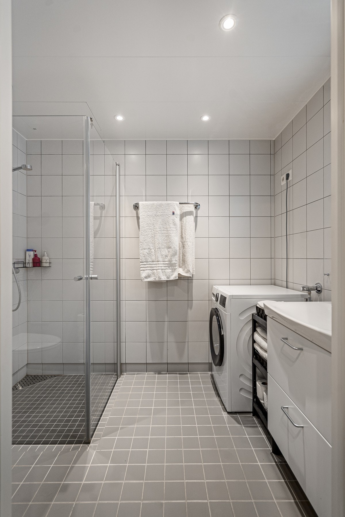 Badet fremstår delikat og moderne med flislagte gulv og vegger i tidsriktige fargevalg. Galleribilde