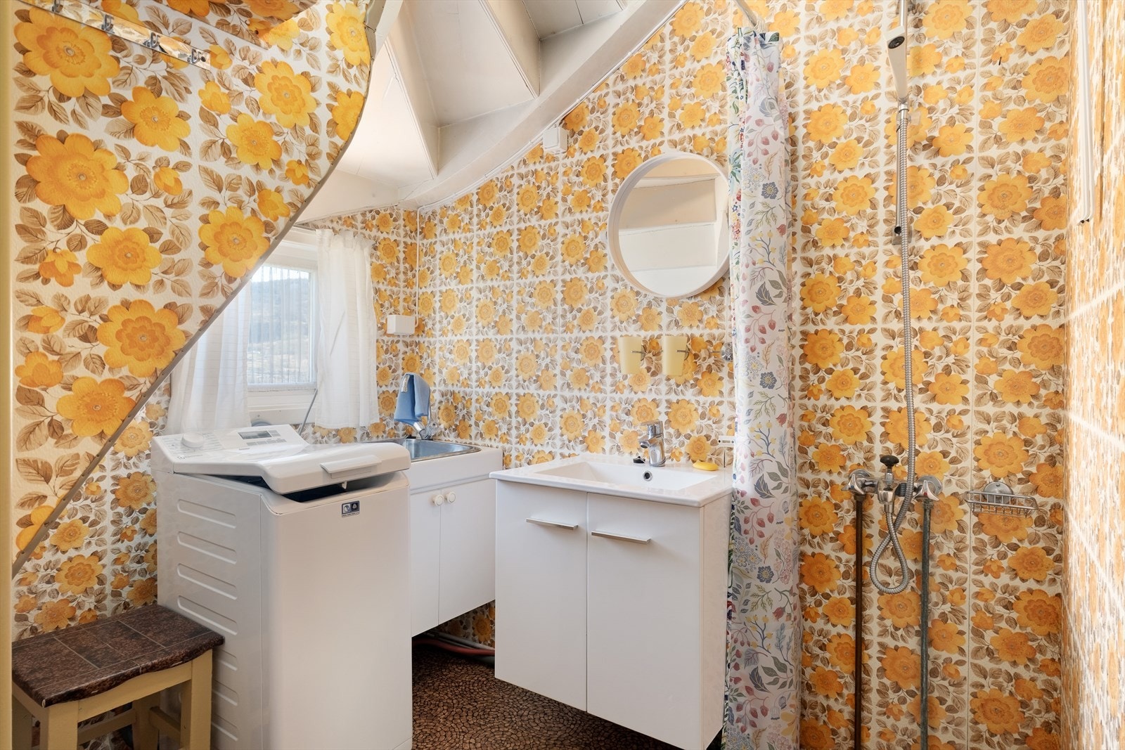 Badet er kombinert med vaskerom og har belegg på golvet og tapet på veggane. Galleribilde