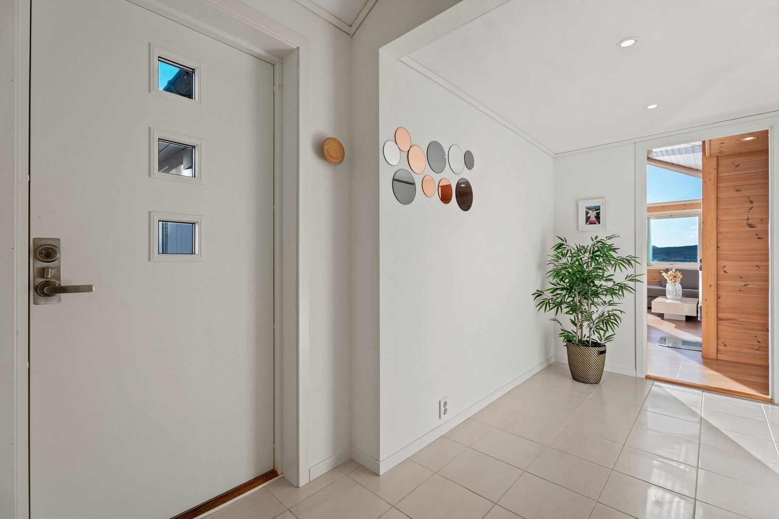 Romslig flislagt entrè på 7,4m² med downlights i himling. Galleribilde