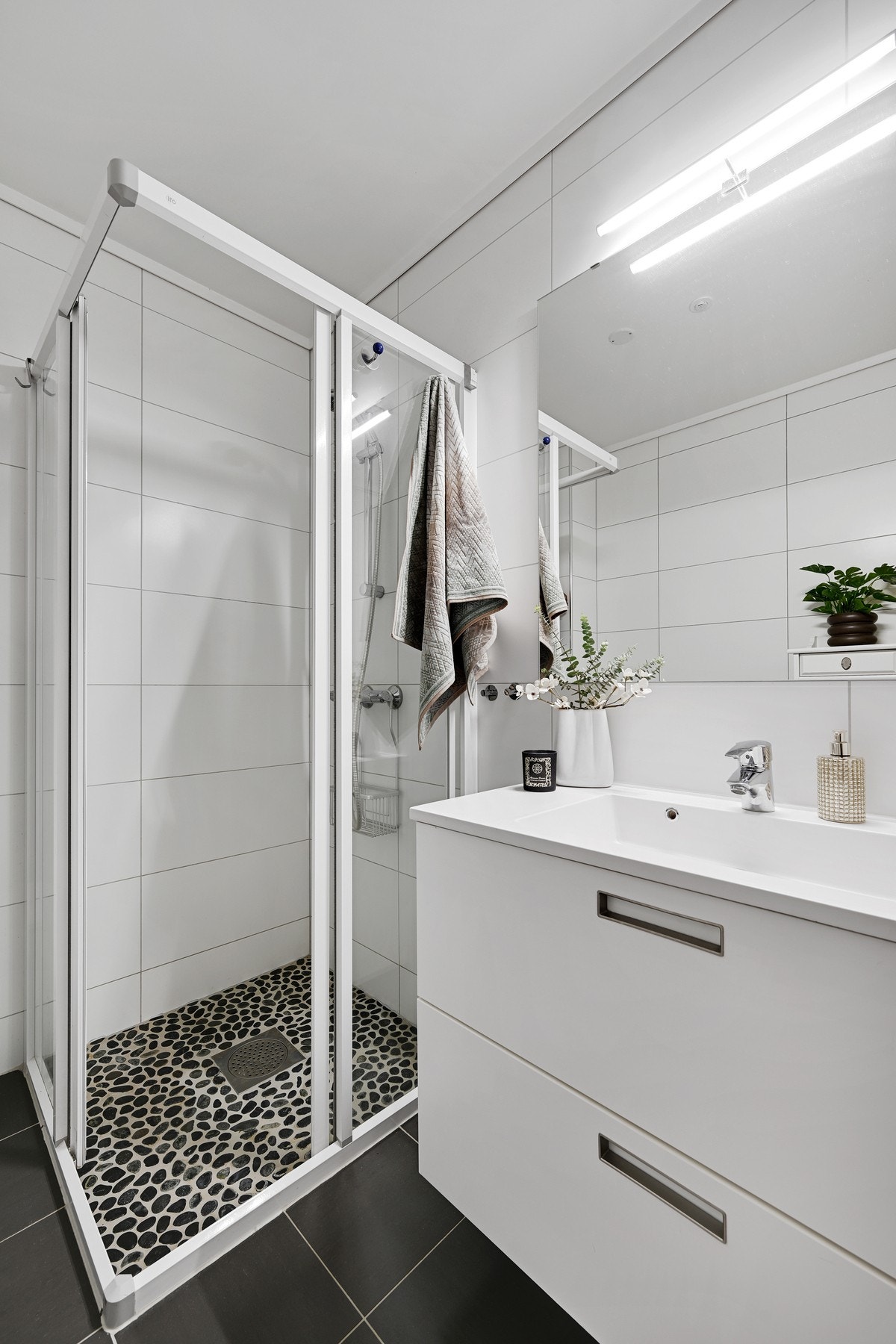 Badet er innredet med vegghengt toalett, dusjhjørne og innredning med nedfelt servant Galleribilde