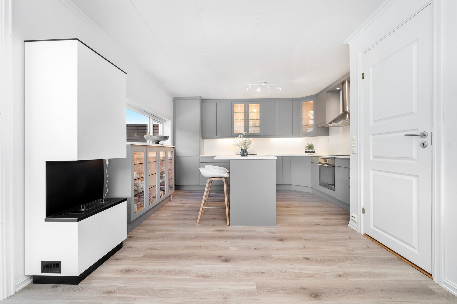 Flott kjøkken med innredning som har integrerte hvitevarer og godt med skap og benkeplass. Fra kjøkken delen er det også dør inn til en praktisk bod under trapp. Galleribilde