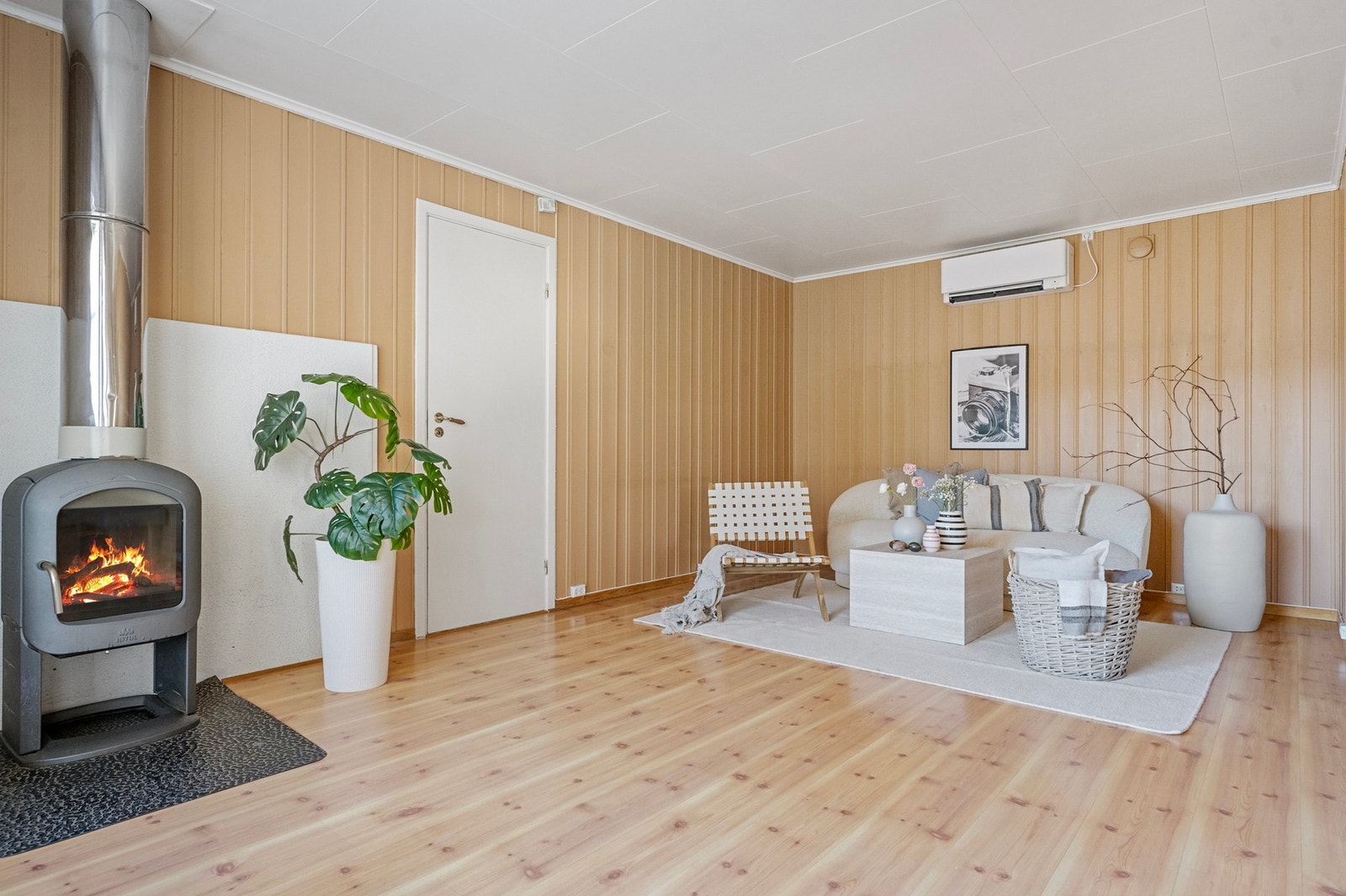 Stuen fremstår lys og hyggelig, med vedovn som bidrar til både varme og trivsel. Galleribilde