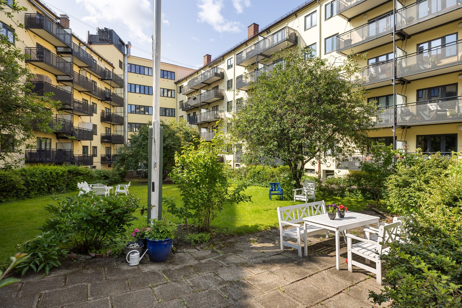 Bakgården er pent opparbeidet med gressplen, beplantning og flere hyggelige sittegrupper. Galleribilde