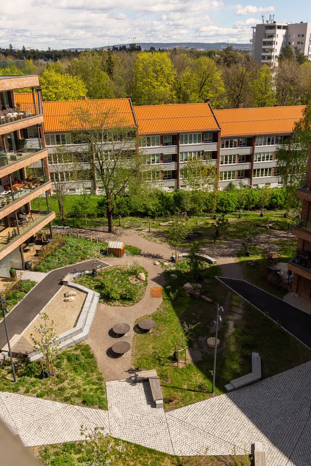 Byggene rammer inn et felles tun med åpning i alle himmelretninger. Dette gir sollys og ivaretar naturlige gangstier over tomten. Galleribilde