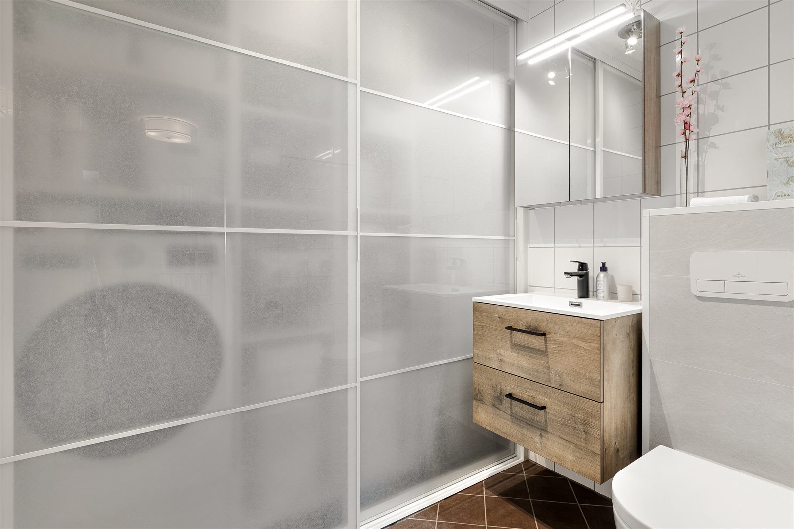 Servant med underskap og speilskap gir praktisk oppbevaring på vaskerommet. Smart skyvedørsløsning for diskret skjerming av vaskemaskin og oppbevaring på badet. Galleribilde