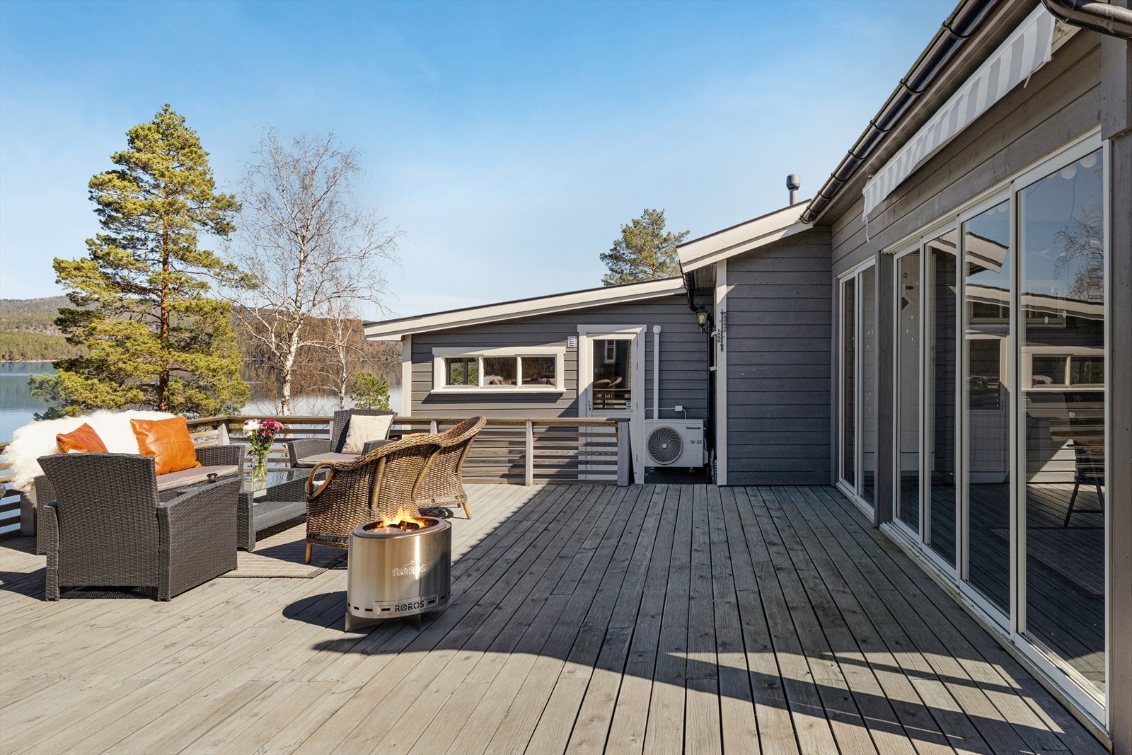 Store, sammenhengende terrasseområder i trekonstruksjon omkranser hytta. Galleribilde
