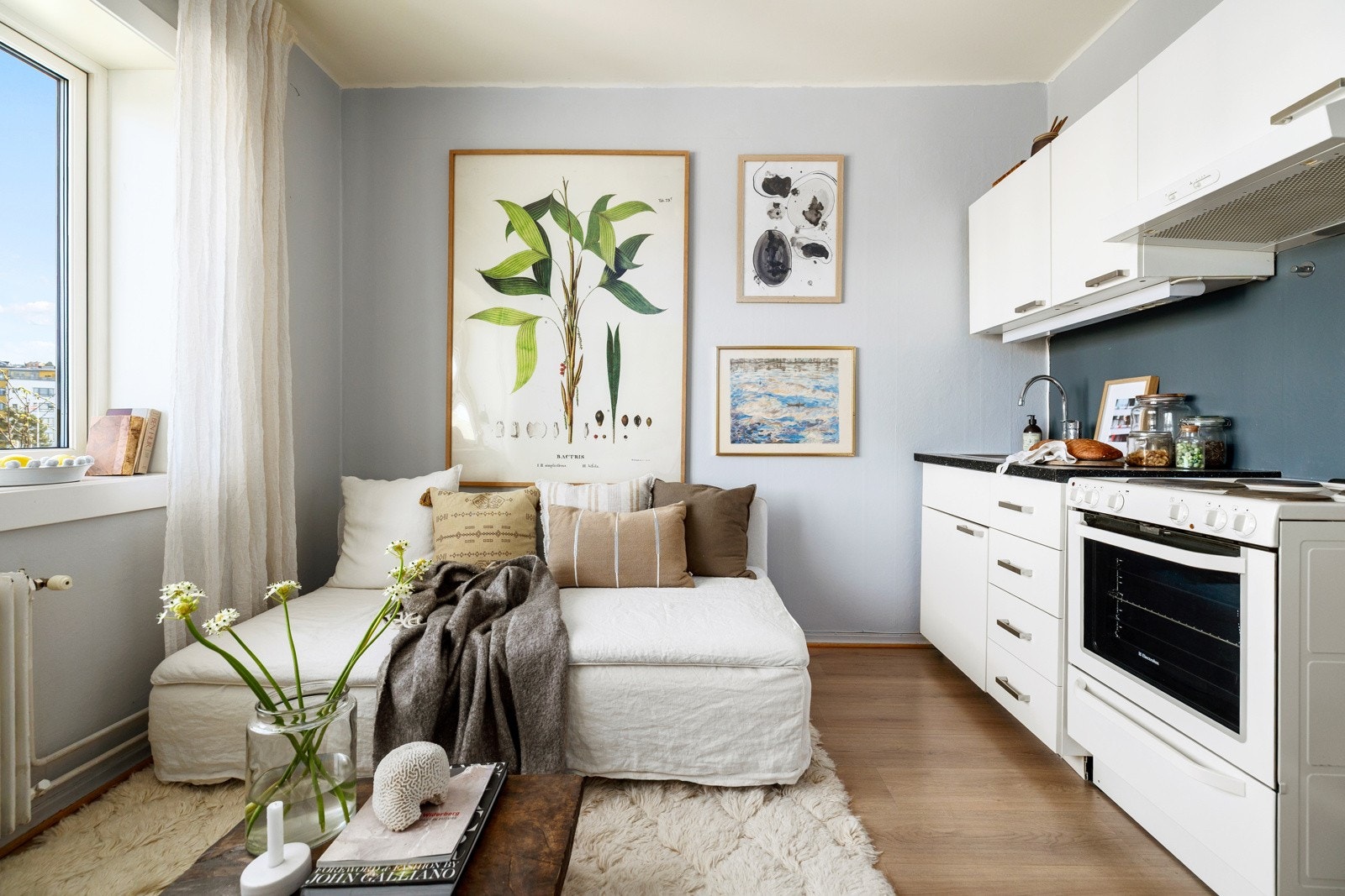 Leiligheten har et lyst oppholdsrom med store vindusflater som slipper inn rikelig med naturlig lys Galleribilde