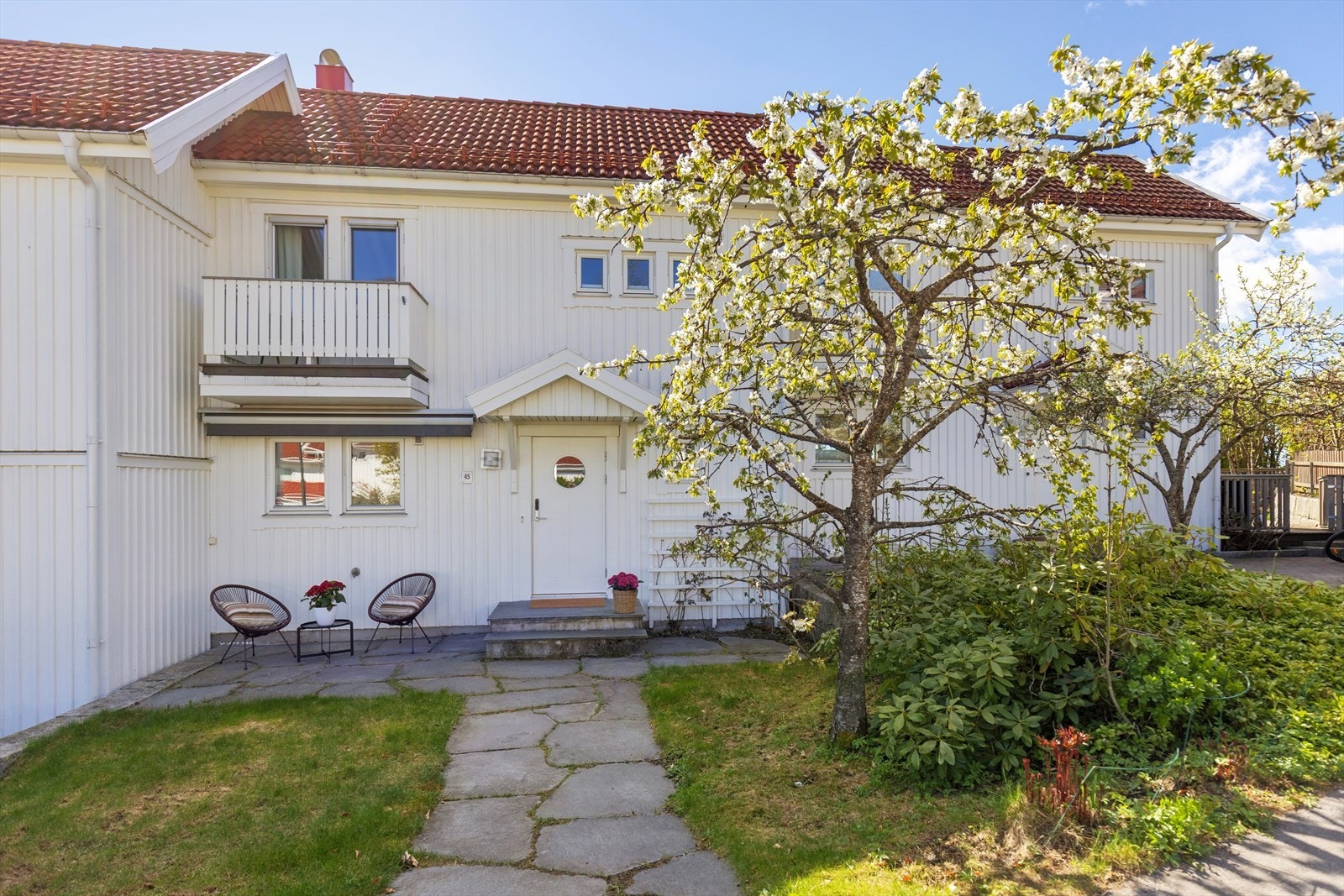 Inngangspartiet har et overbygget tak og adkomst via en sti i naturstein. Galleribilde