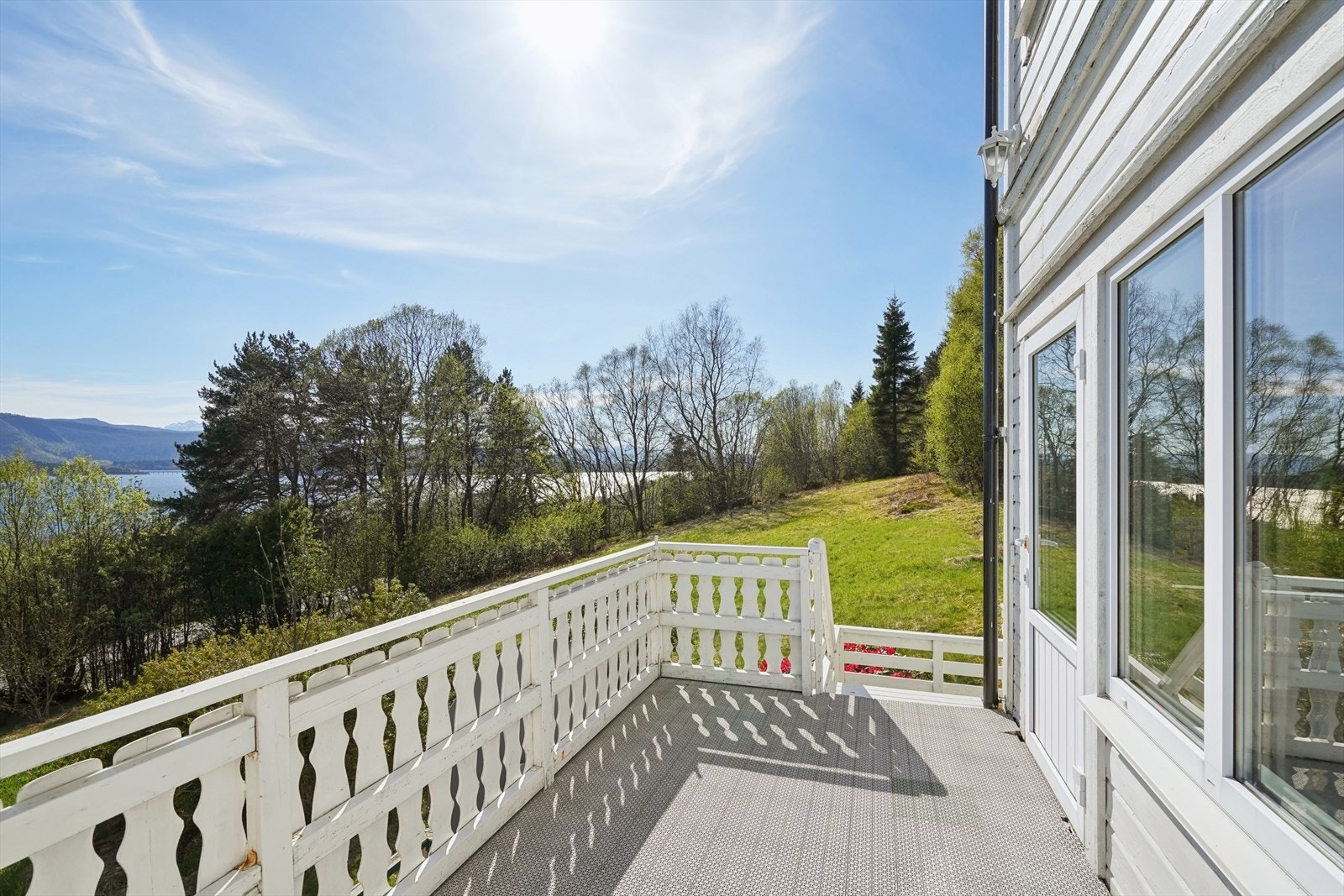 Romslig, sør- og vestvendt veranda med god plass til sittegruppe. Galleribilde