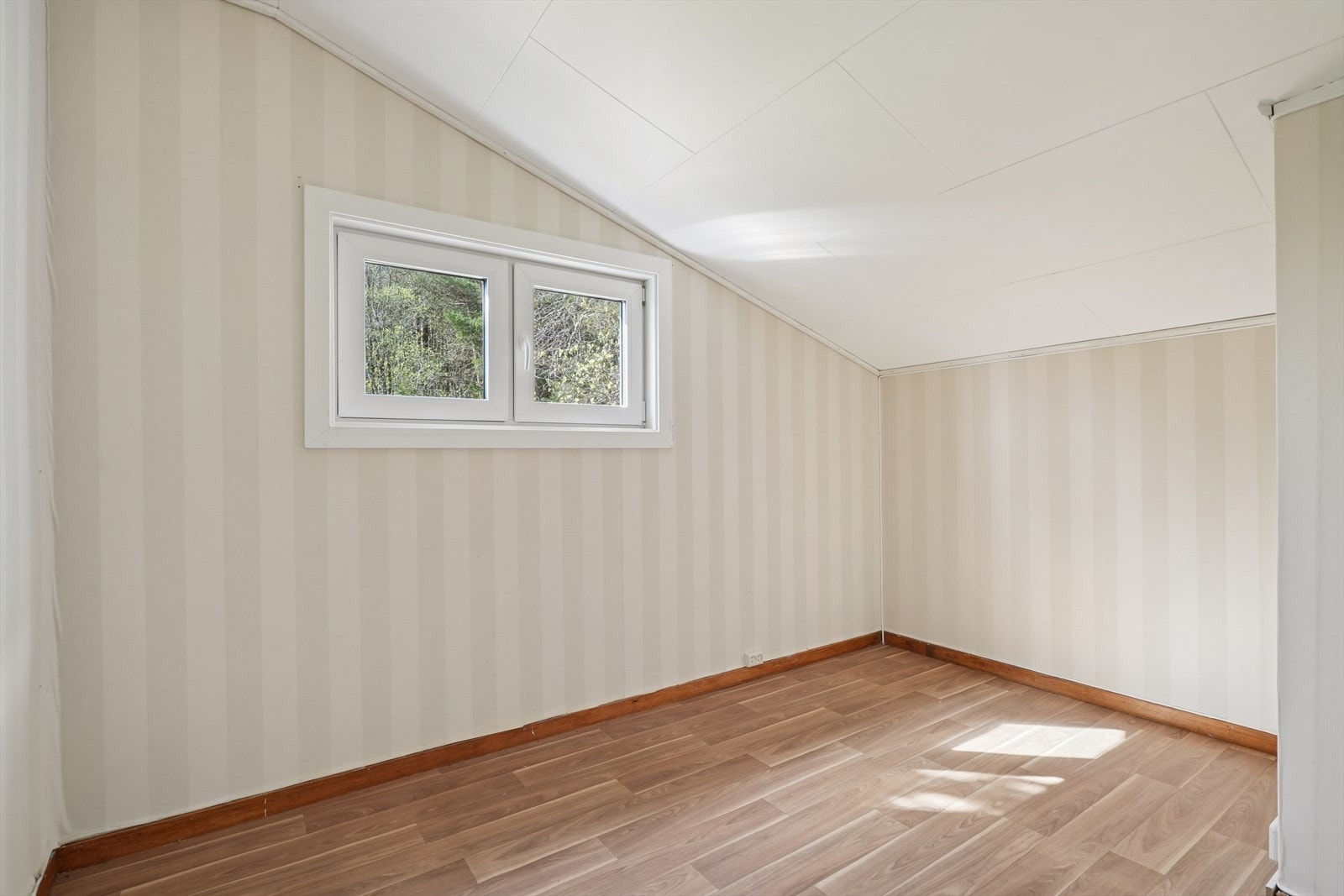 Soverom med laminatgulv og tapetserte vegger. Galleribilde