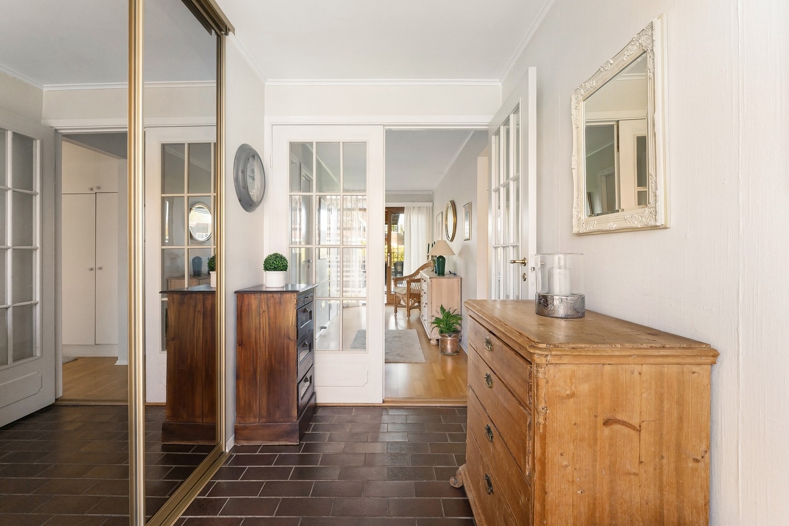 Fra yttergangen åpner boligen seg opp med doble glassdører inn mot stuen. Stor skyvedørsgarderobe med speil gir god plass til oppbevaring av sko og yttertøy. Galleribilde