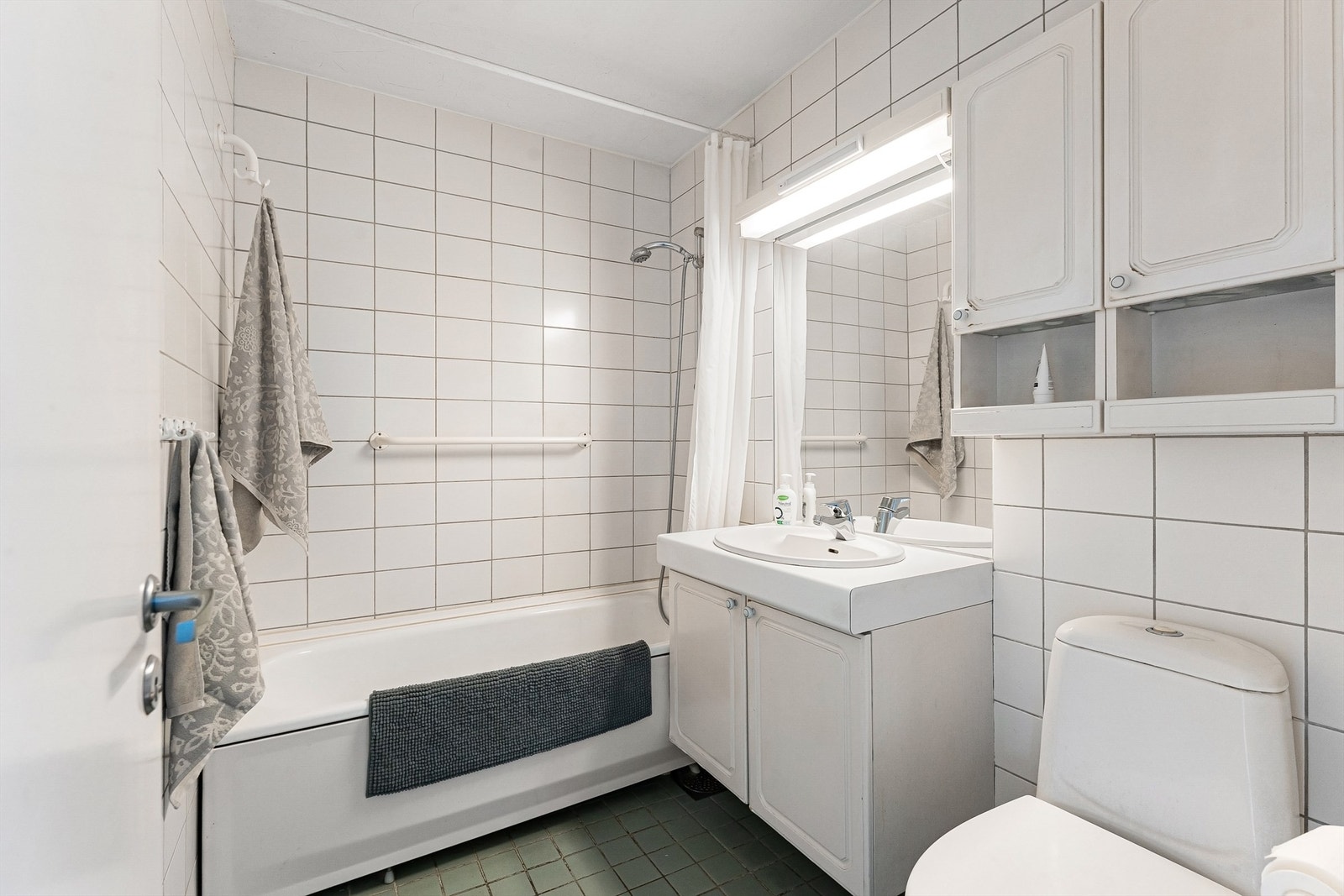 Badet i hovedetasjen er fra byggeåret, med flislagt gulv med gulvvarme og badekar. Galleribilde