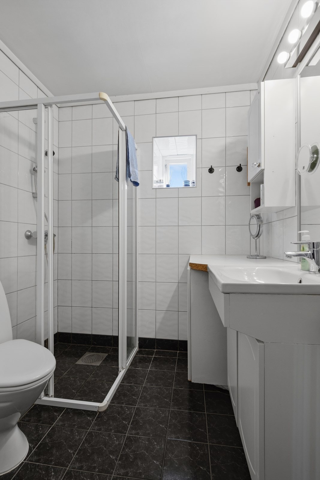 Badet er flislagt og har elektrisk gulvvarme. Rommet er innredet med dusjhjørne, wc og servantinnredning. Galleribilde