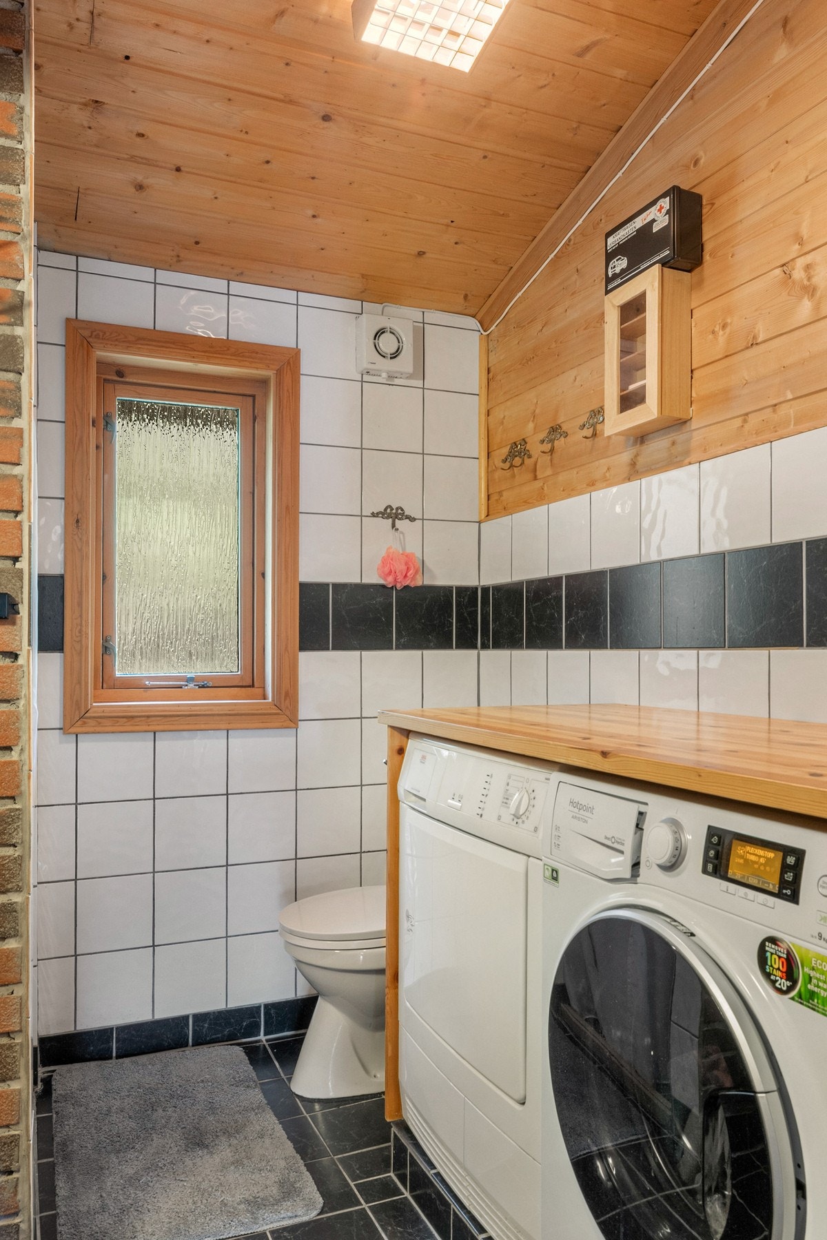 Innredet med innredning med nedfelt servant, toalett, dusjhjørne og opplegg for vaskemaskin. Galleribilde