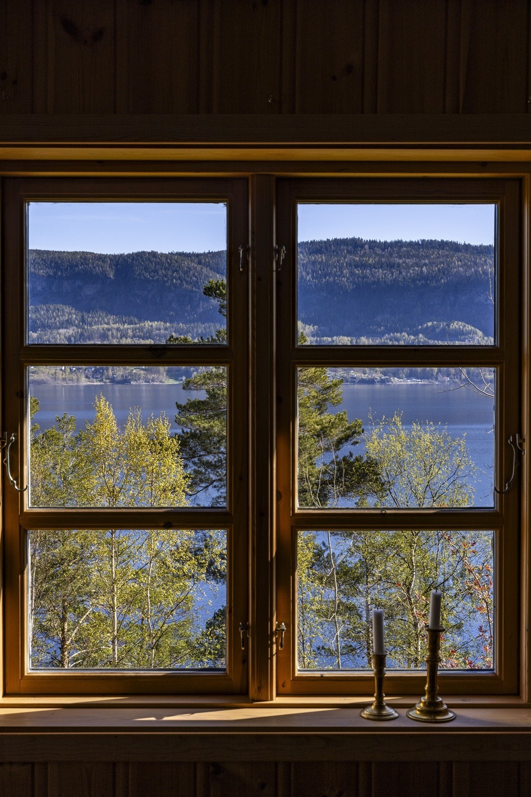 Utsikten rammes inn av malte trevinduer. Galleribilde