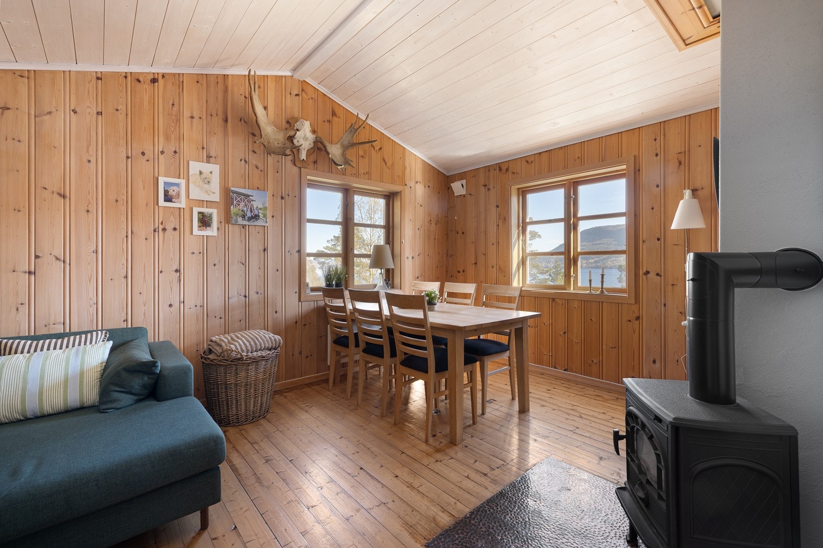 Stuen har god plass til både spisebord og sofagruppe. En vedovn av nyere modell sørger for varme og hygge. Galleribilde