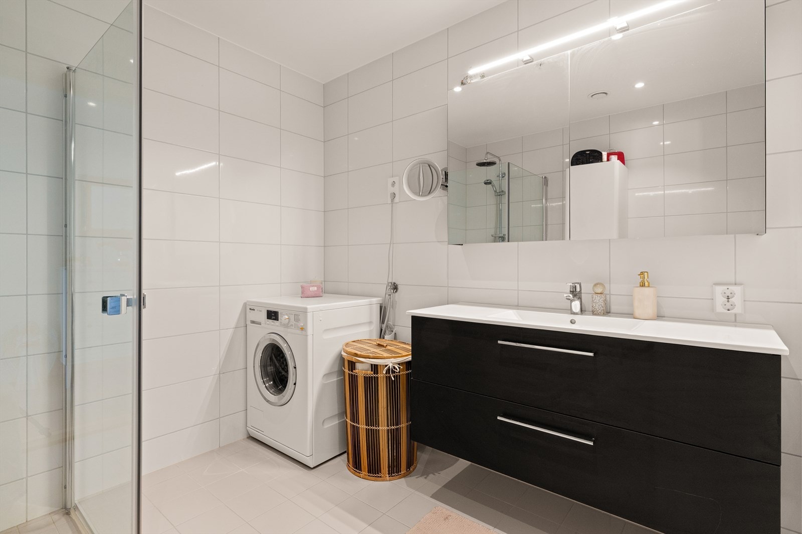 Badet har elektriske varmekabler i gulvet, dusjhjørne med glassdører og opplegg for vaskemaskin. Galleribilde