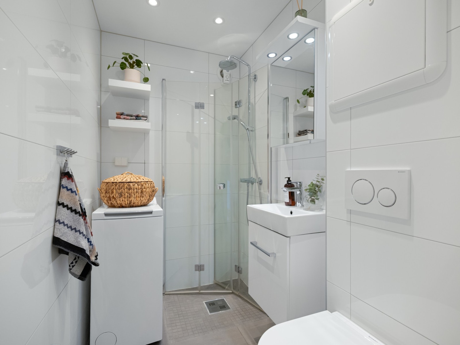 Badet er innredet med dusjhjørne med regnfallsdusj, servantskap og speil. Det er både plass og opplegg for vaskemaskin. Galleribilde