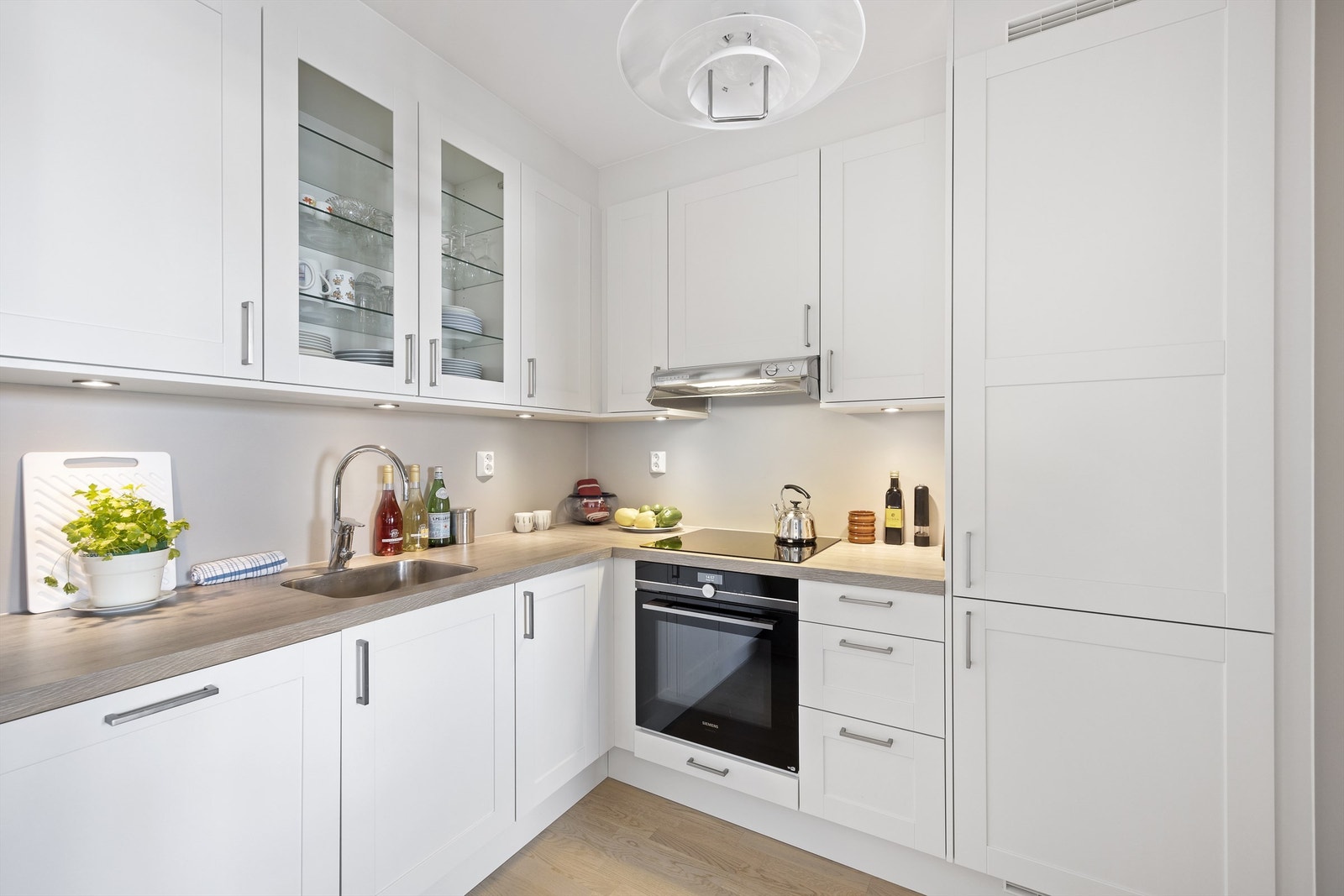 Åpen kjøkkenløsning mot stue. Flott Norema kjøkkeninnredning med profilerte fronter og benkeplate med laminert overflate. Integrerte hvitevarer som stekeovn med pyrolyse, platetopp, oppvaskmaskin og kjøleskap med fryser Galleribilde