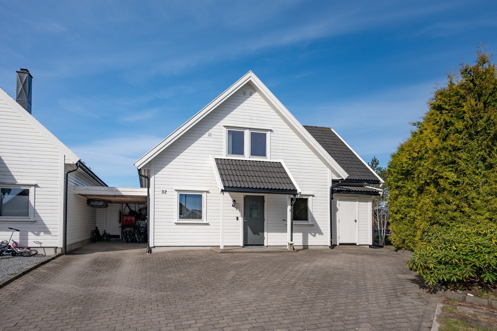 Pent gårdsrom med belegningsstein, til venstre ser du carporten, til høyre ser du snekkerbod/utebod. Galleribilde