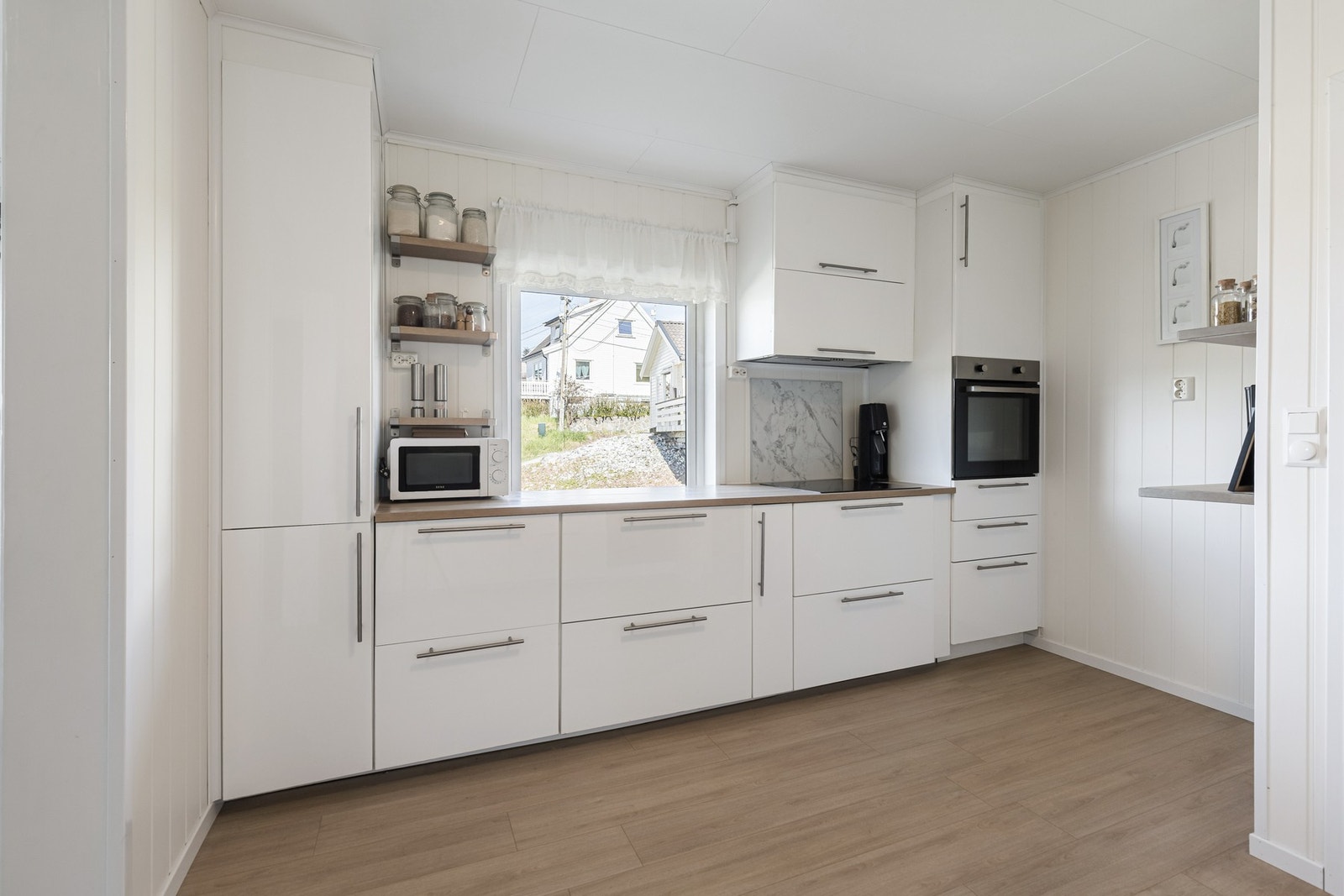 Moderne kjøkken med stilrene fronter og god benkeplass. Galleribilde