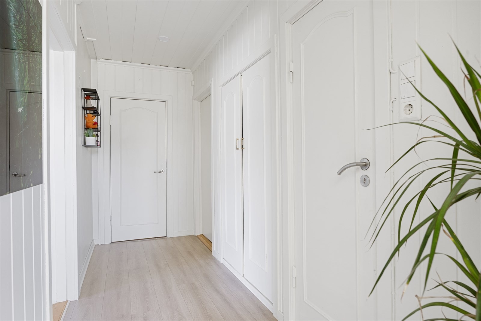 Lyse overflater og laminatgulv går igjen i gangen. Galleribilde