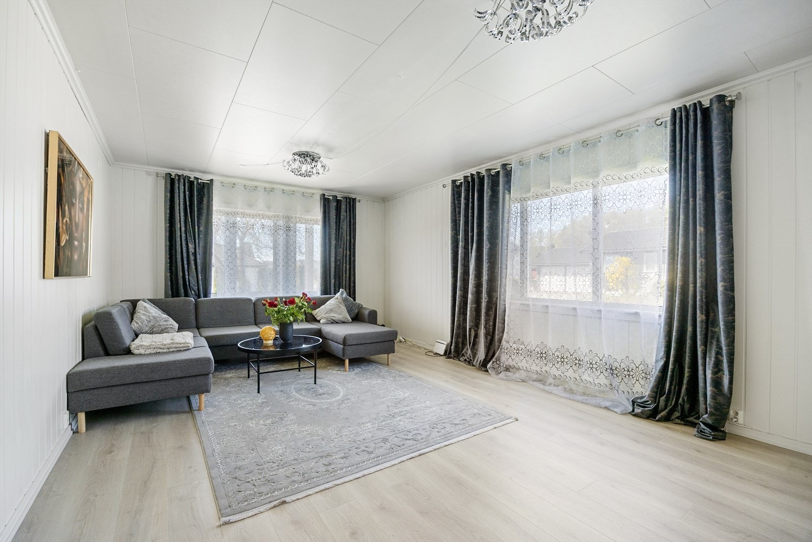 Stuen i første etasje har god plass til en romslig sofagruppe. Overflatene består av laminat på gulv og panelplater på veggene. Galleribilde