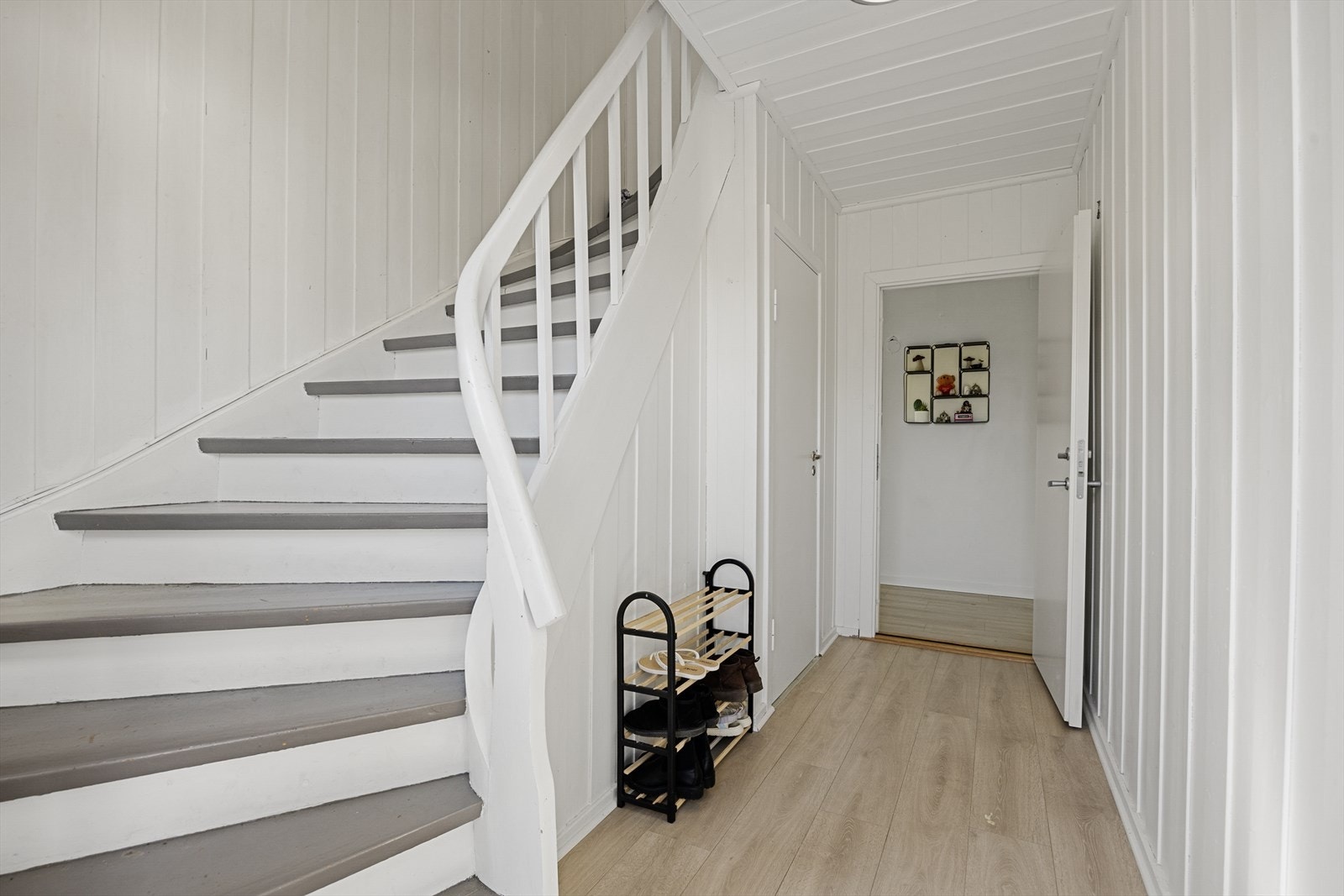Felles inngangsparti med malt tretrapp som leder opp til andre etasje. Galleribilde