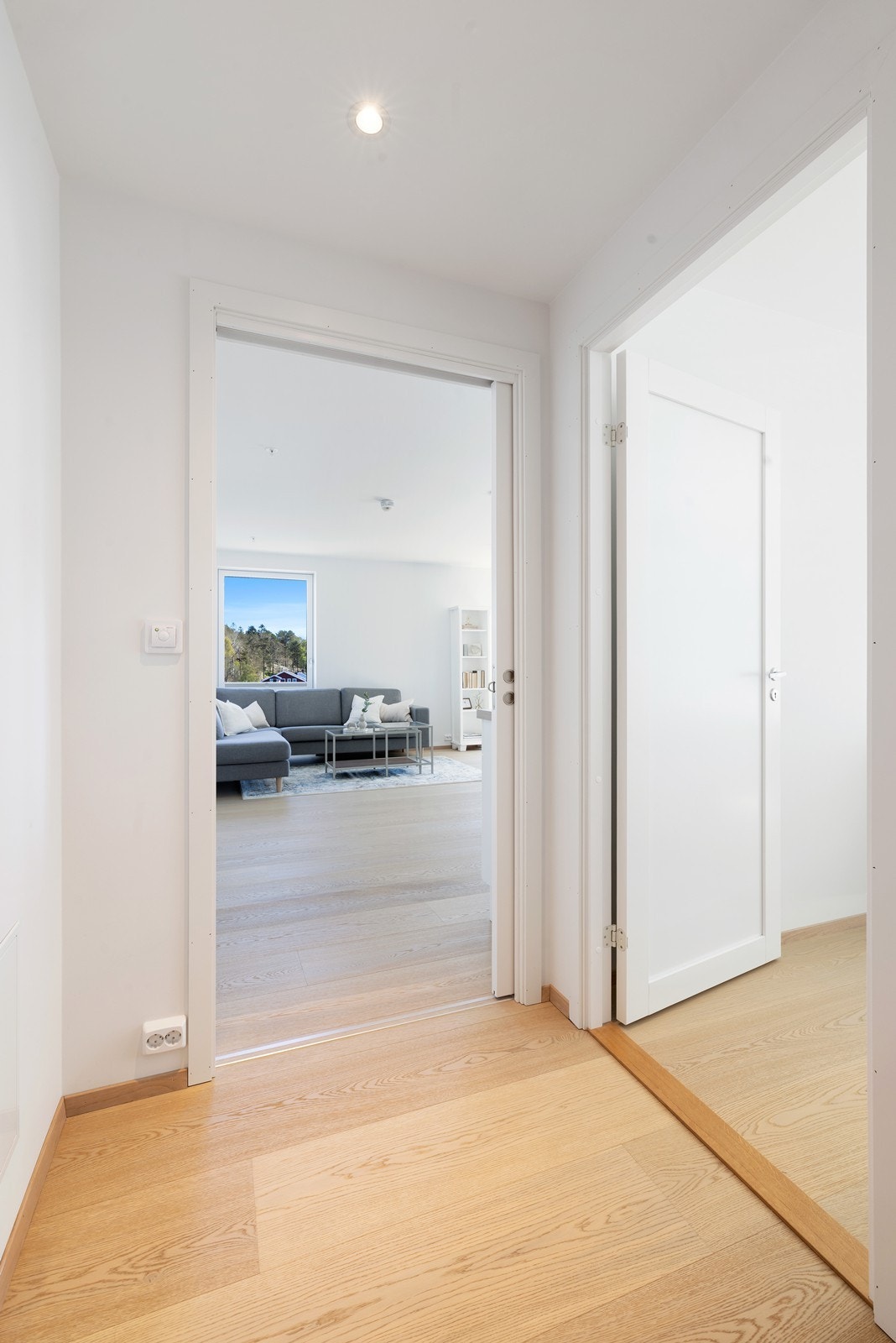 Videre inn i leiligheten finner du hhv. hovedsoverom (t.h.) og stue. Galleribilde