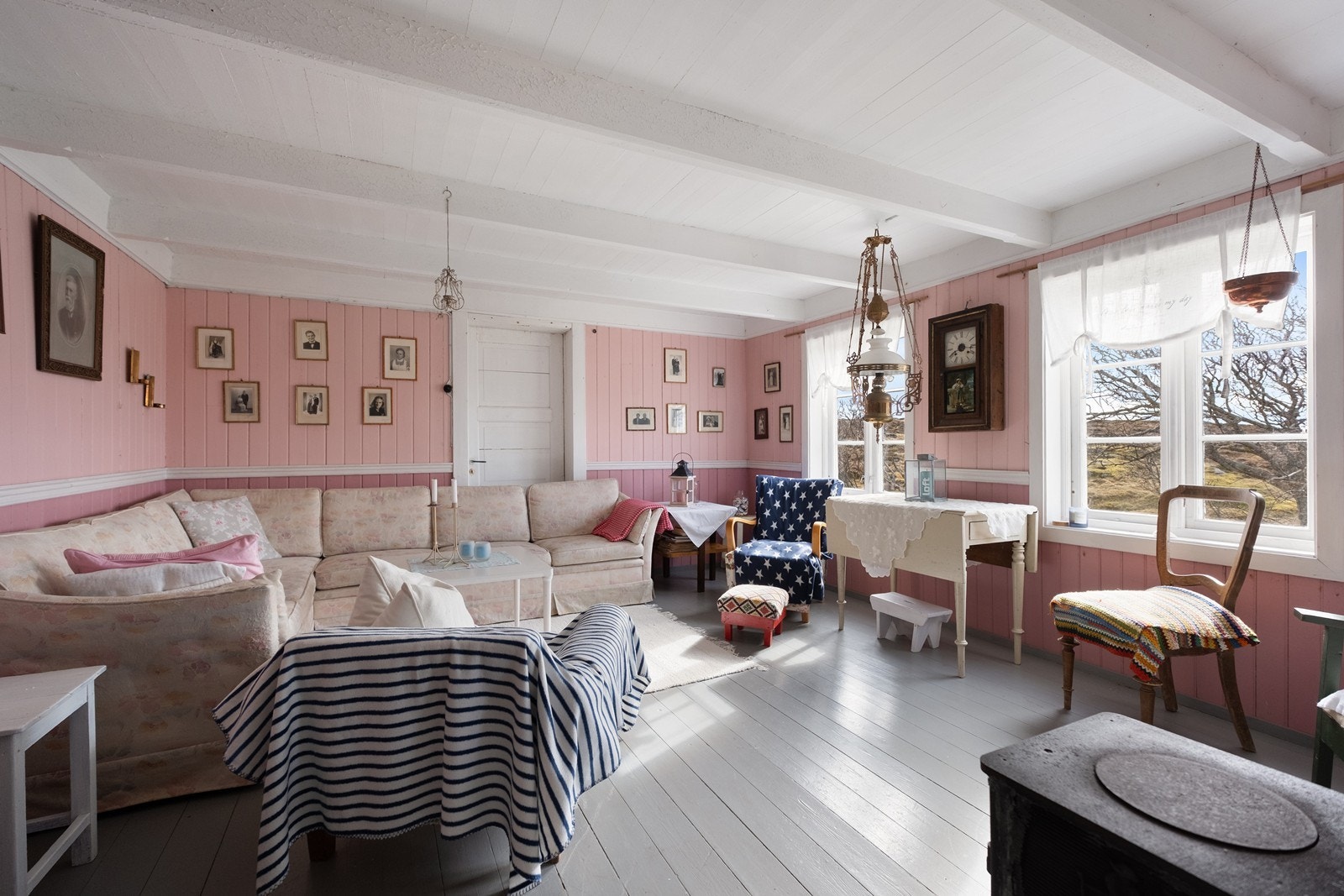 Stuen har panelte vegger og store vinduer mot sør, som gir godt med naturlig lys. Galleribilde