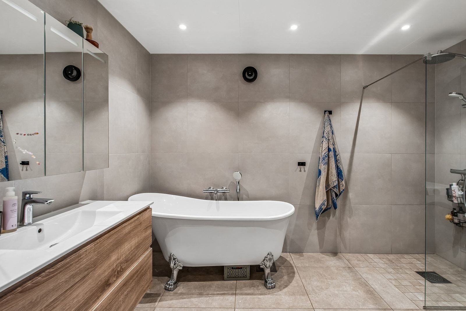 Moderne og komplett flislagt bad med store og elegante fliser. Badekar og dusj med waterfall.