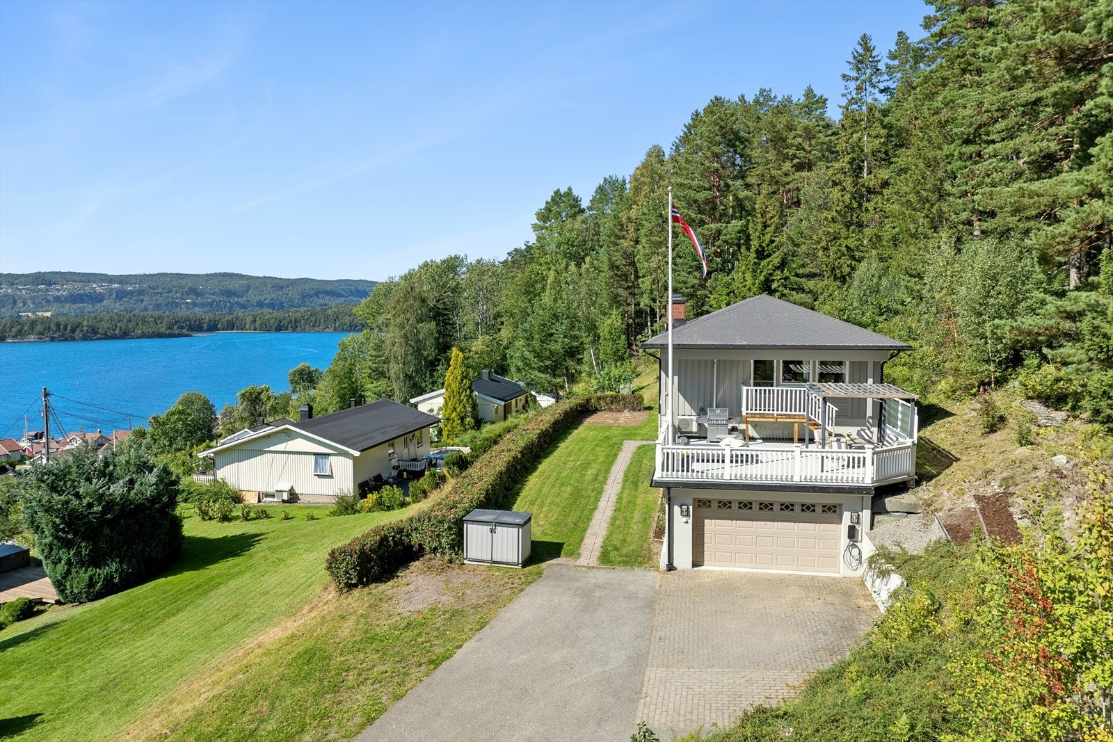 Det er parkering i dobbelgarasje og plass til flere biler i gårdsplassen, som er har både steinbelagte og asfaltere områder. Det er montert elbillader utvendig på garasjenveggen. Galleribilde