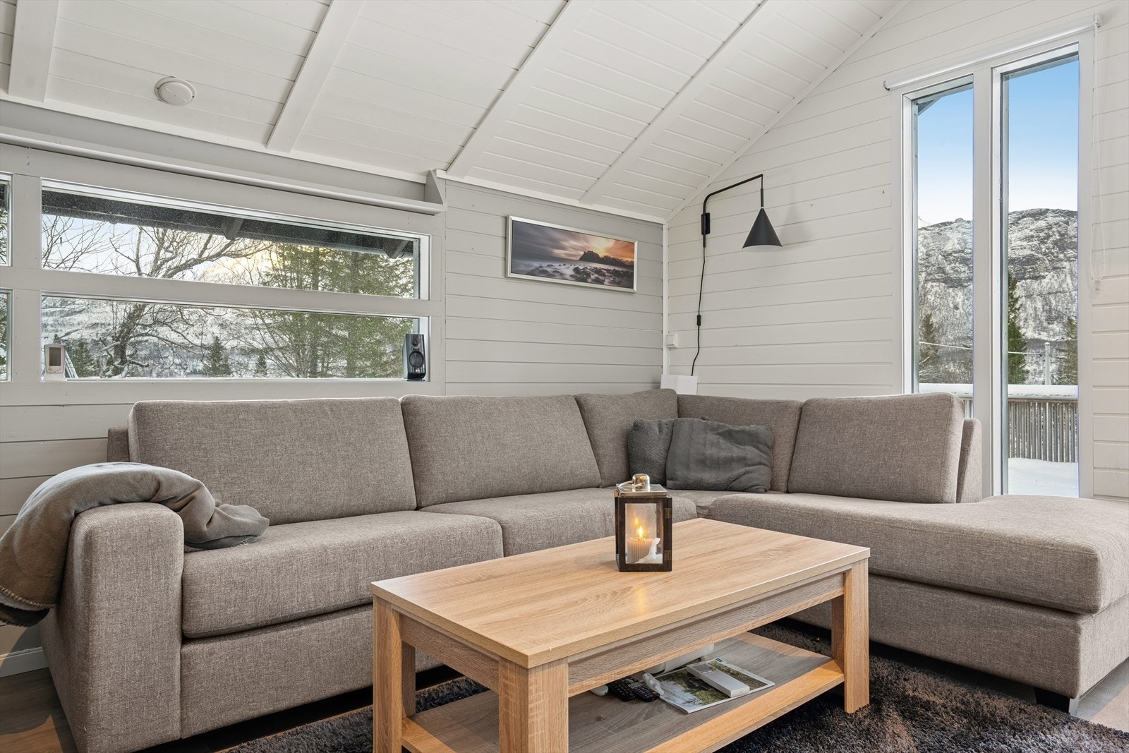 Sofagruppen får en flott plassering ved de store vinduene, som gir rikelig med naturlig lys og åpner opp for en naturskjønn utsikt. Galleribilde